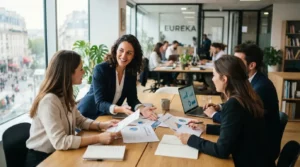 Professionnel en portage entrepreneurial échangeant avec des clients potentiels dans un bureau moderne, ambiance dynamique, documents commerciaux et ordinateur sur la table.